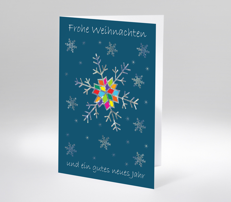 Weihnachtskarte mit bunter Schneeflocke auf blauem Hintergrund und Text Frohe Weihnachten und ein gutes neues Jahr