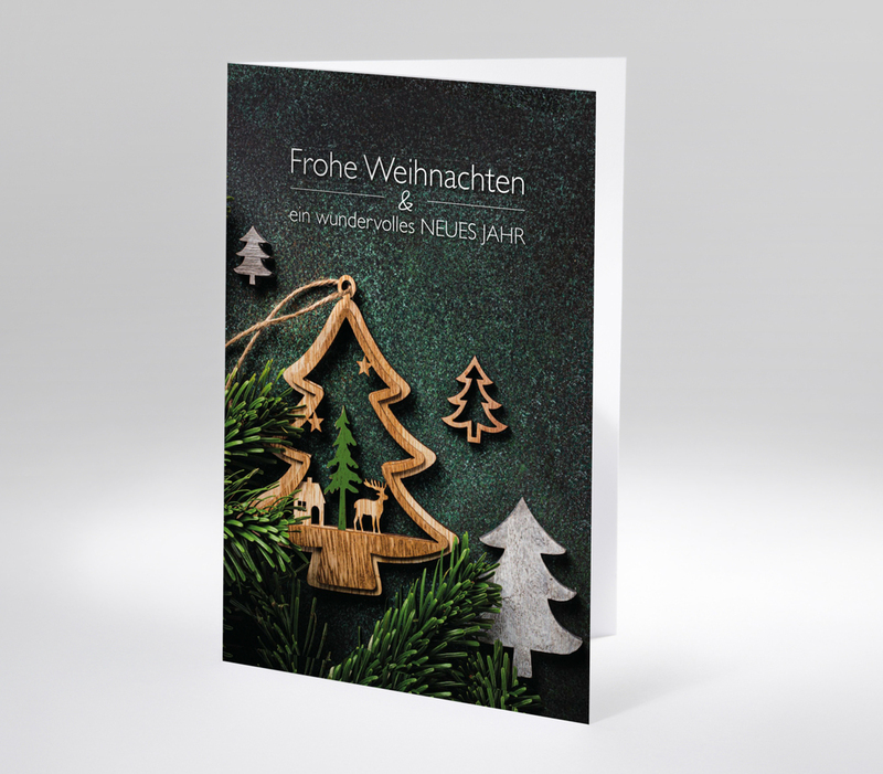 Stimmungsvolle Weihnachtskarte mit Holzdeko in Tannenform, Tannenzweigen und Text Frohe Weihnachten & ein wundervolles neues Jahr